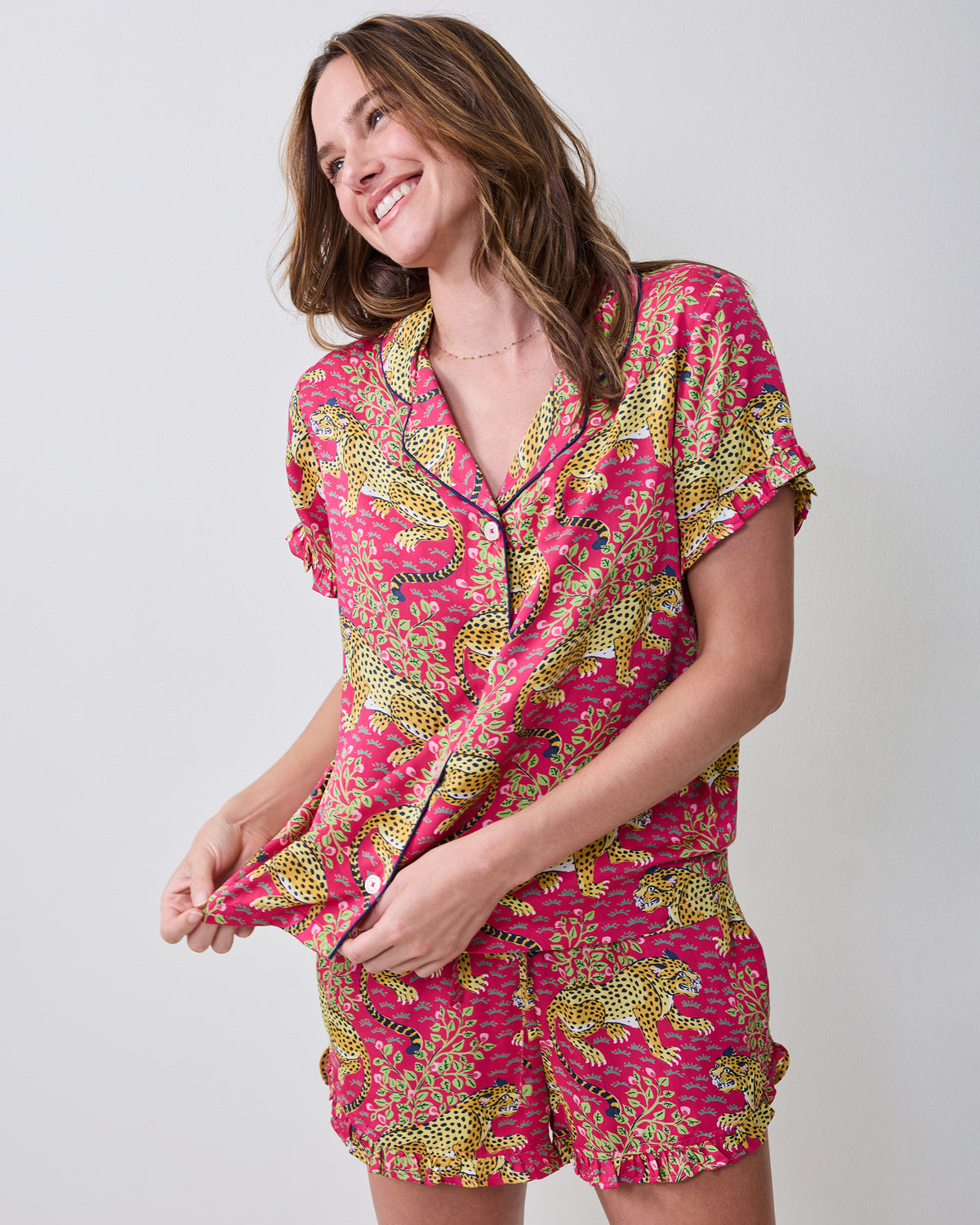 Angled front view of a model wearing the hot pink Bagheera leopard-print ruffle short pajama set.