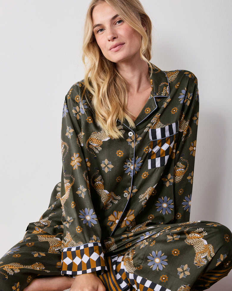 Close front view of the olive Rittenhouse pajama shirt, showing its notched collar, button front, chest pocket, leopard and flower print, and checkerboard cuffs.