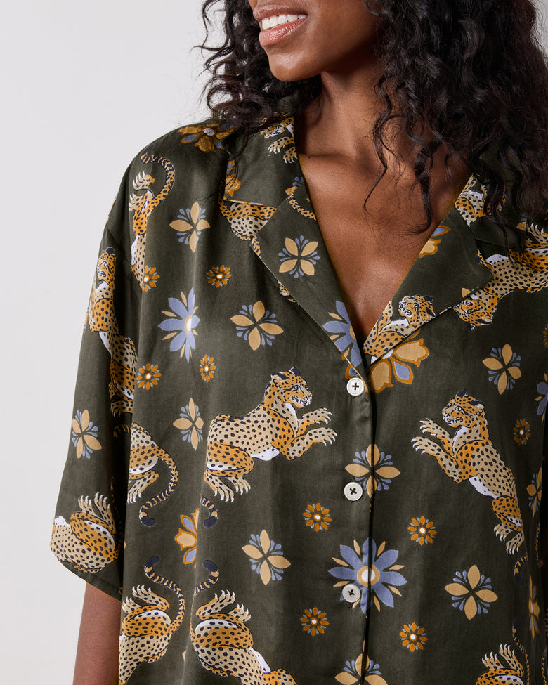 Close view of the olive Wildest Dreams pajama shirt, showing its notched collar, button front, short sleeves, and leopard and flower print.