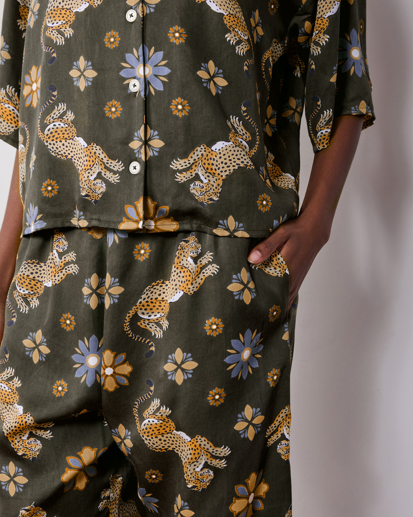 Close view of the olive Wildest Dreams pajama shirt and matching pants, showing the leopard and flower print and side pocket.