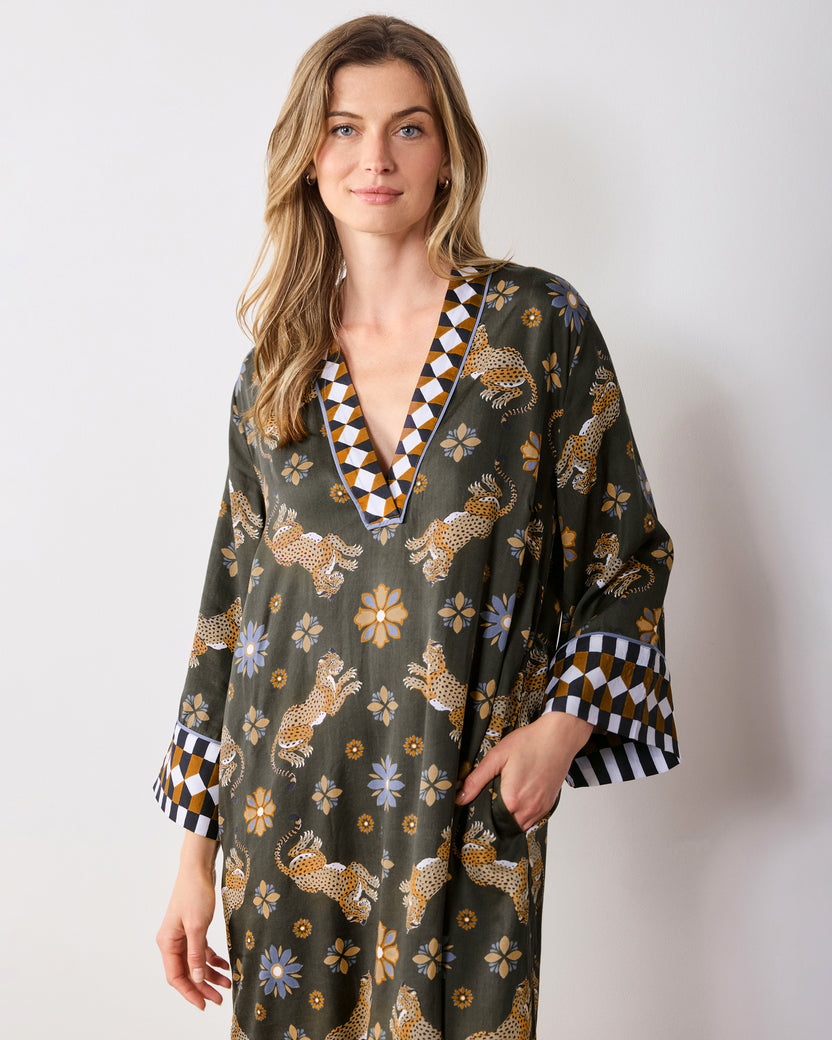 Front three-quarter view of the olive Bagheera Kaleidoscope Kennedy caftan with a V-neck, wide cuffs, leopard-and-flower print, and side pockets.