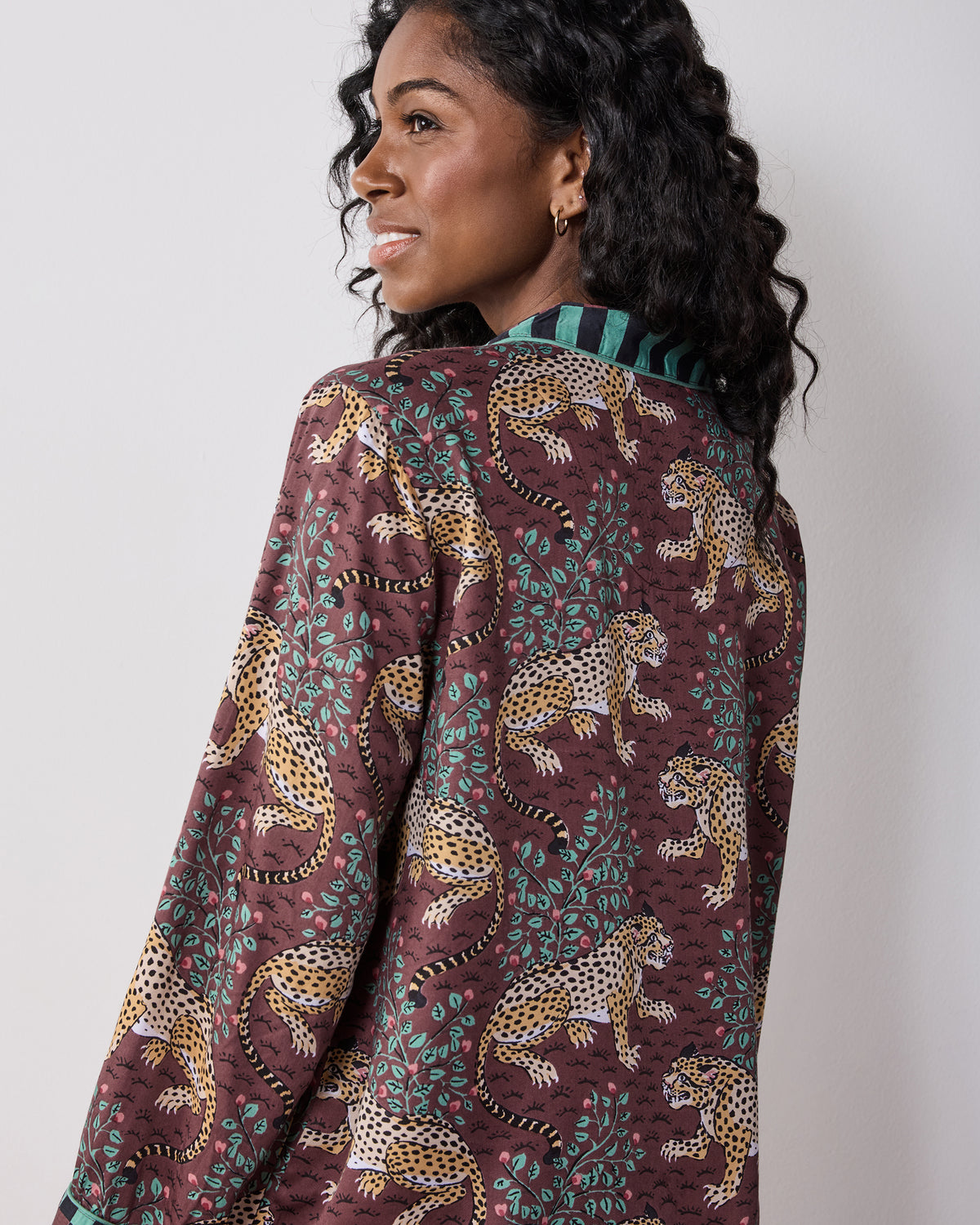 Close back view of the raisin Bagheera pajama top, showing the leopard print, leafy motifs, and contrasting checkered collar.