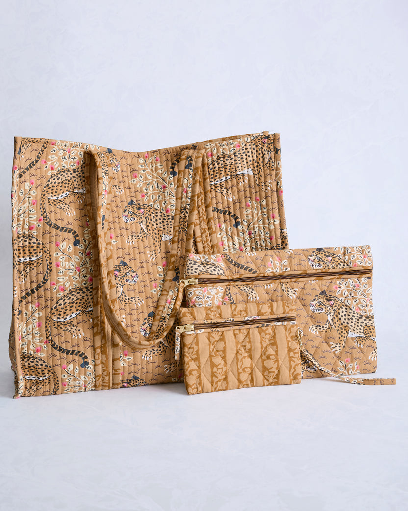Tobacco-colored quilted tote and two zip pouches with a repeating leopard and floral print.