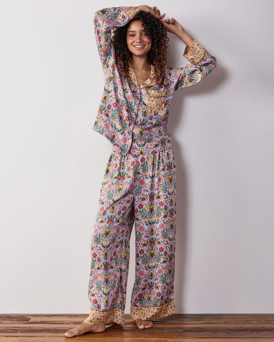 Full view of the lavender Bee Tapestry pajama set with a floral and honeybee print, long-sleeved top, and wide-leg pants.