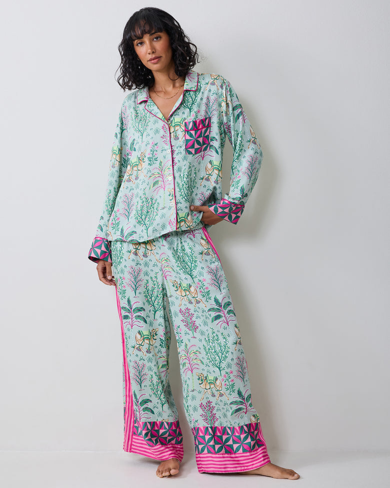 Model wearing the Avocado Camel's Courtyard pajama set, shown in a front three-quarter view with hands in the pants pockets.