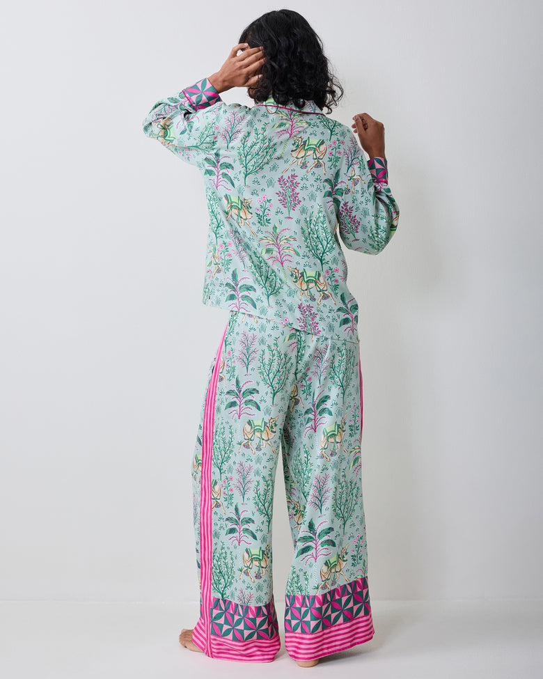 Back view of the model wearing the Avocado Camel's Courtyard petite pajama set with botanical and camel print.