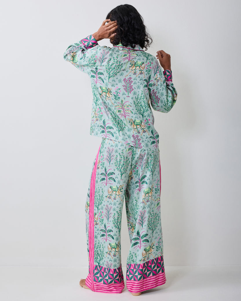 Back view of the model wearing the Avocado Camel's Courtyard petite pajama set with botanical and camel print.