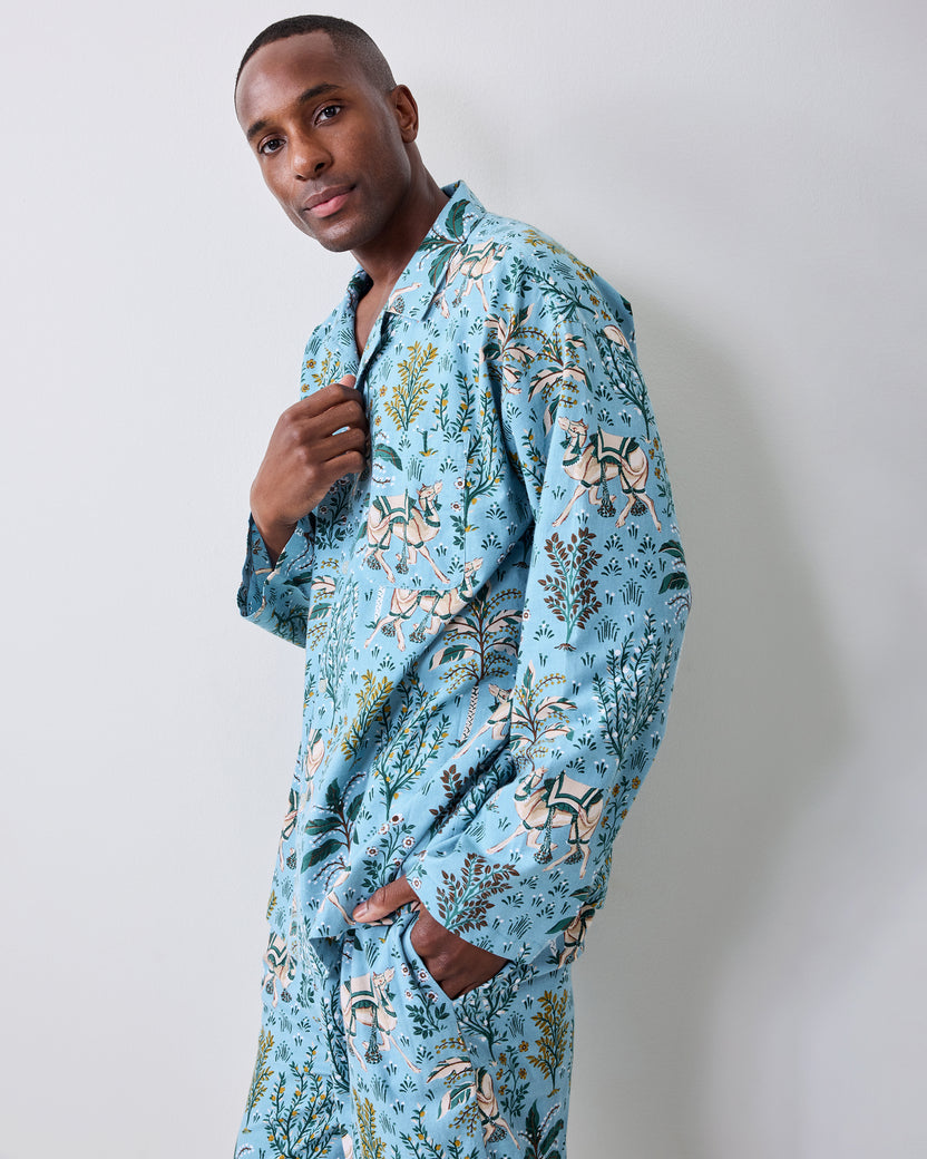 Model wearing the Slate Blue Camel's Courtyard long pajama set in a side view, with one hand in a pants pocket.