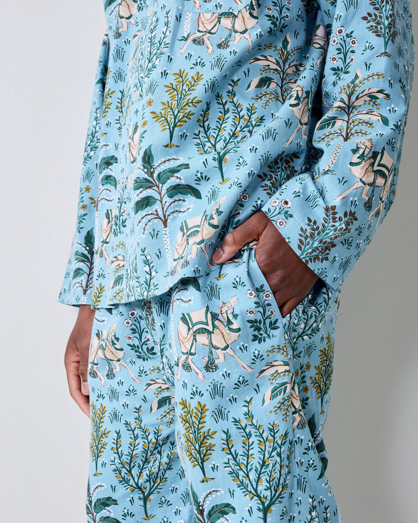 Close-up view of the Slate Blue Camel's Courtyard pajama top and pants, showing the botanical and camel print and a pants pocket.