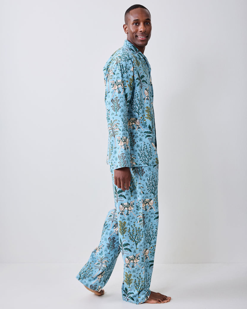 Side view of a model wearing the Slate Blue Camel's Courtyard long pajama set, with one pant leg lifted.