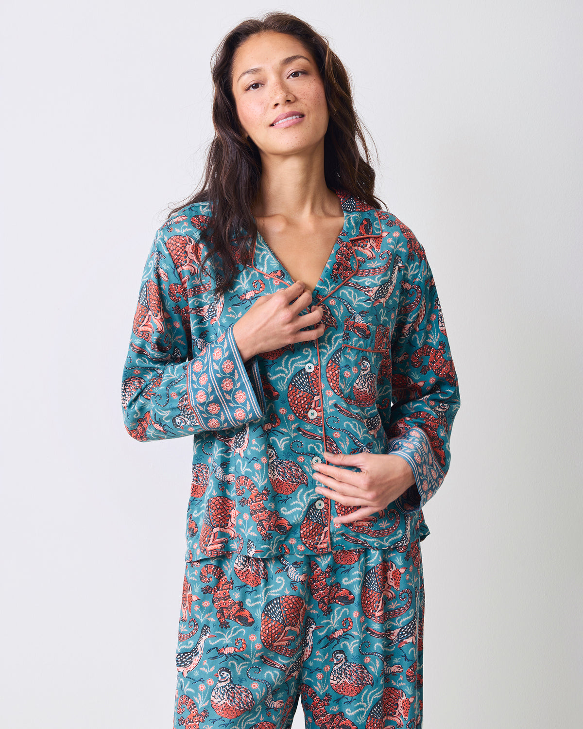 Front detail view of the teal Canyon Critters Petite Eco Satin Soho Set showing the notched collar, buttons, chest pocket, and patterned cuffs.