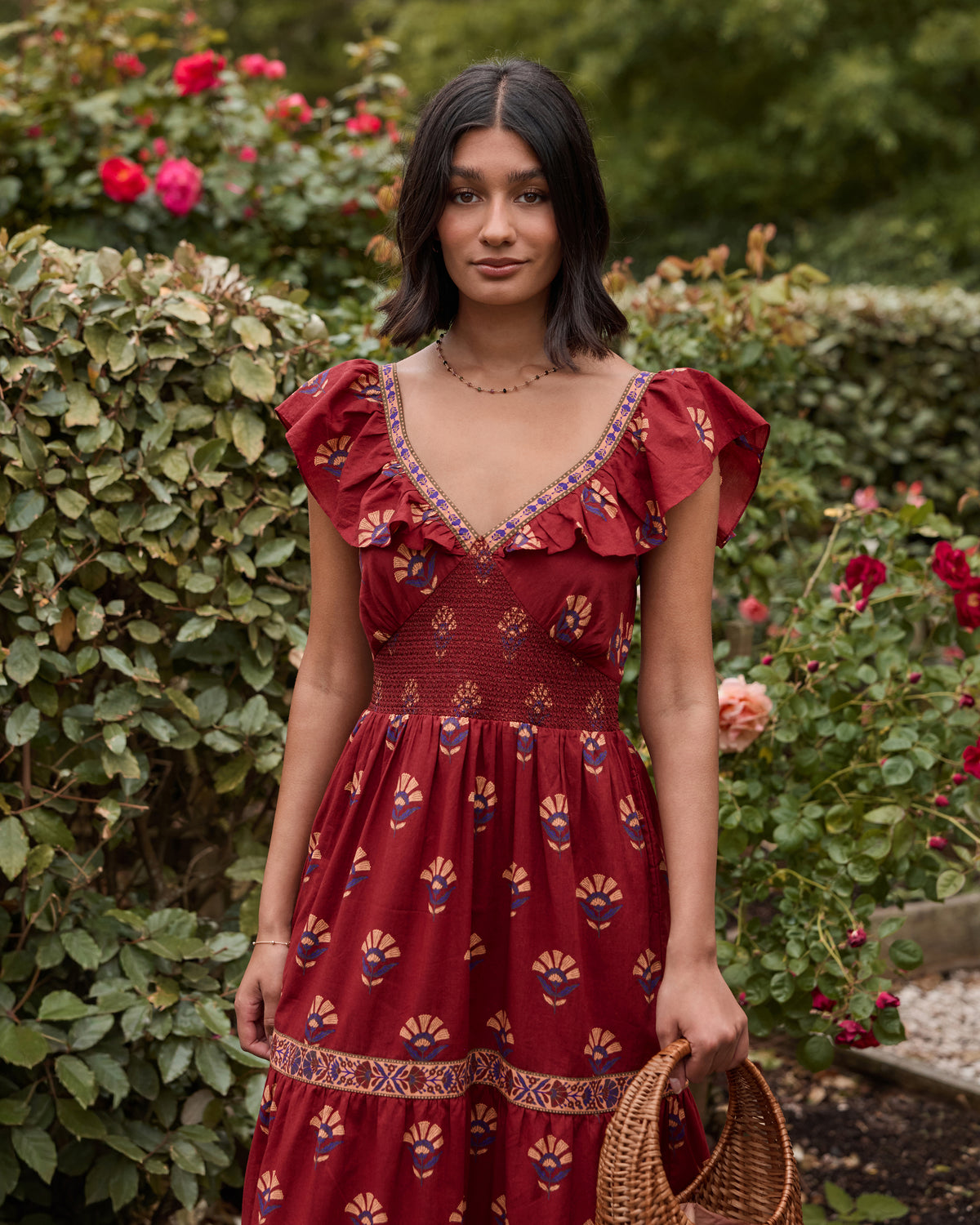 Upper-body view of the Red Rock Cordelia Dress, showing its deep V-neck with trim, ruffle sleeves, smocked bodice, and patterned print.