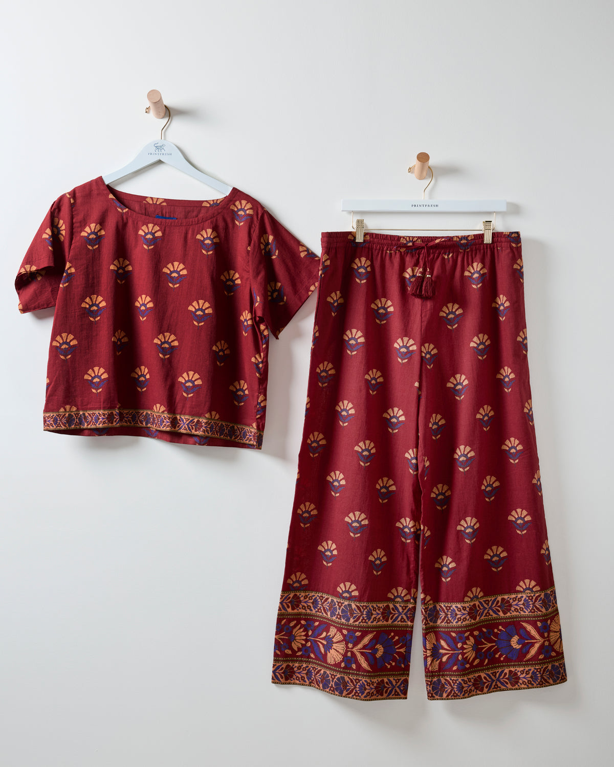 Canyon Wildflower two-piece set in red rock, with a short-sleeved top and wide-leg pants featuring coordinating patterned borders.