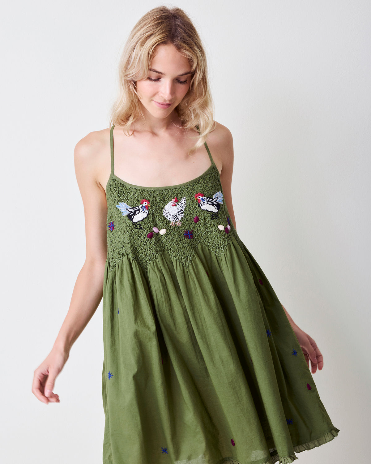 Front view of the olive Tulsi nightie with thin straps, a smocked bodice, chicken motifs, and a ruffled hem.