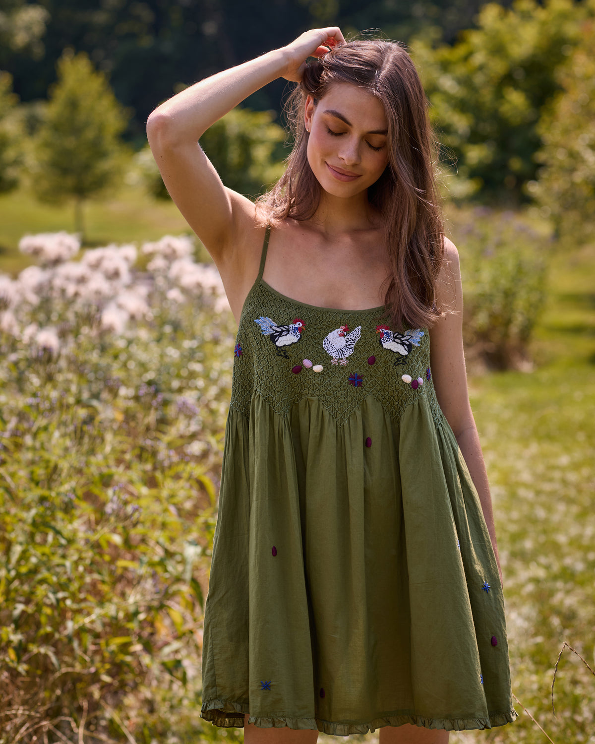 Front view of the Chickens & Roosters Tulsi nightie with an olive background, chicken print, thin shoulder straps, and gathered skirt.