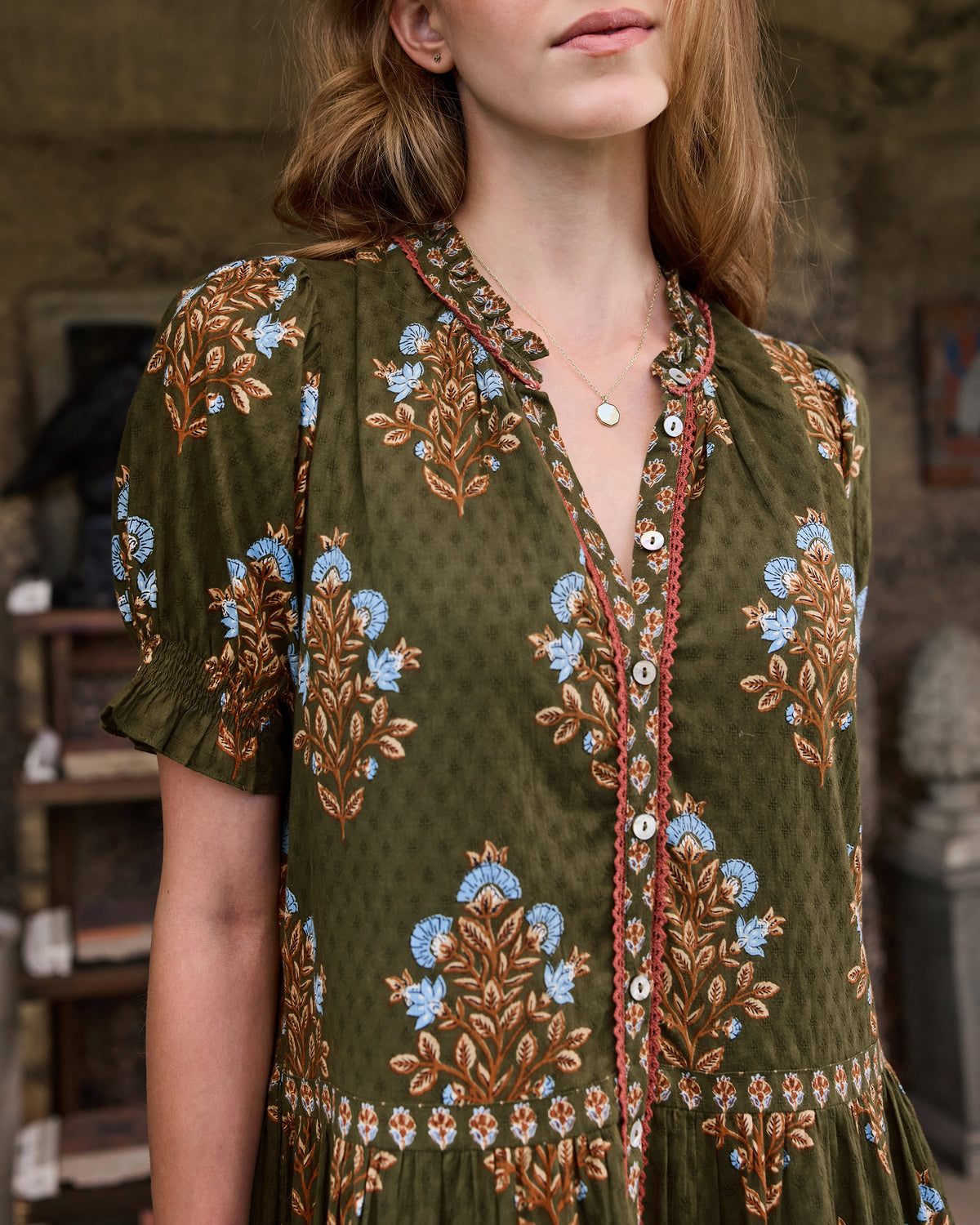 Close front view of the Colorado Wildflowers Bella Dress in deep olive, showing the floral print, V-neckline, buttons, and short sleeves.
