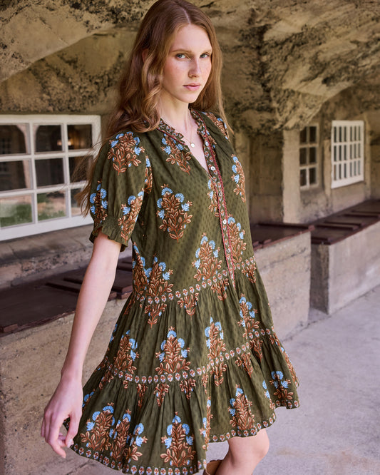 Front three-quarter view of the Colorado Wildflowers Bella Dress, showing the floral print, buttoned neckline, short sleeves, and tiered skirt.