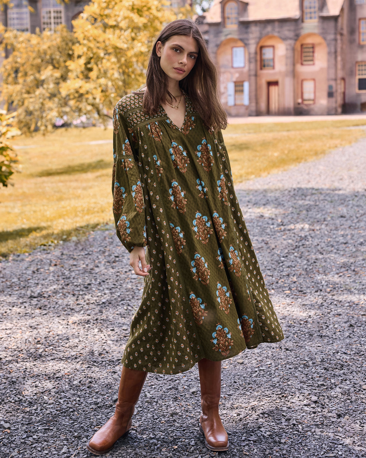 Front three-quarter view of the deep olive Tallulah dress with long sleeves and floral print.