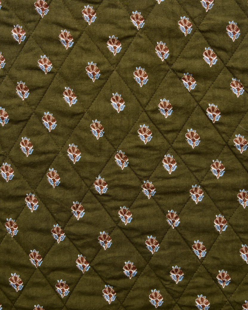 Deep olive quilted fabric swatch with small repeating brown and blue floral motifs.
