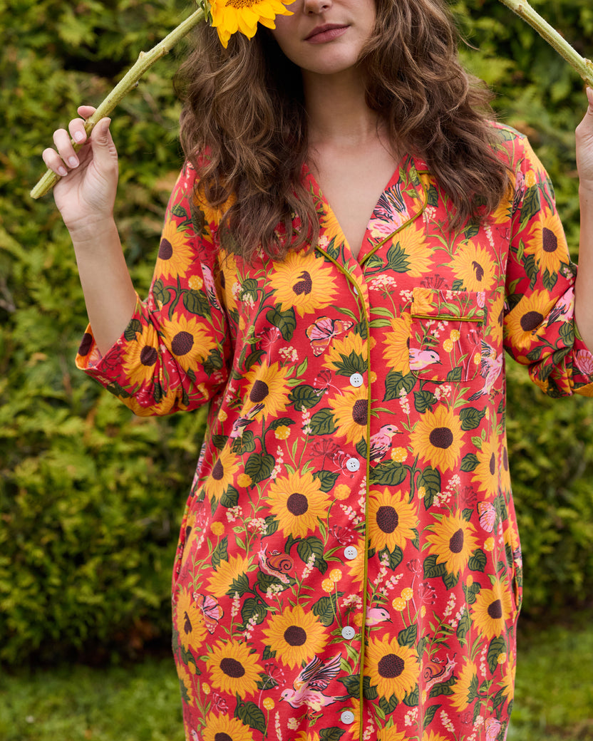 Close view of the orange floral sleep shirt showing its notched collar, button front, chest pocket, and patterned sleeves.
