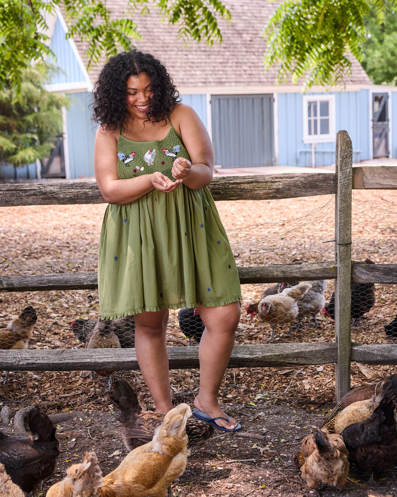 Olive Tulsi nightie with embroidered chicken motifs, shown on a person standing near a chicken enclosure.