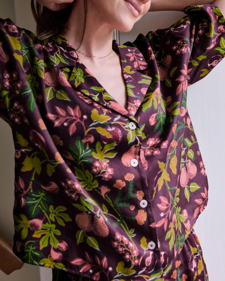 Close-up of the plum floral-print pajama top with a notched collar, drop shoulders, and button front.