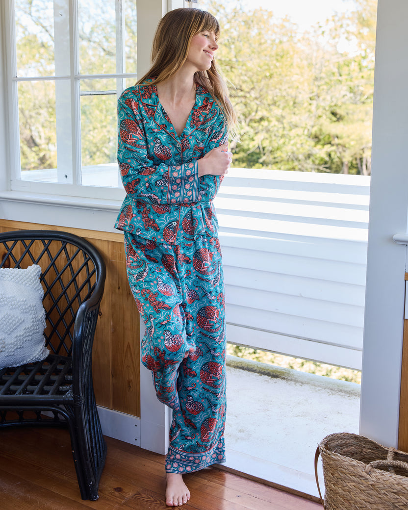 Full-length view of the teal Southwestern Critters satin Soho pajama set with a long-sleeve button-front top and matching pants.