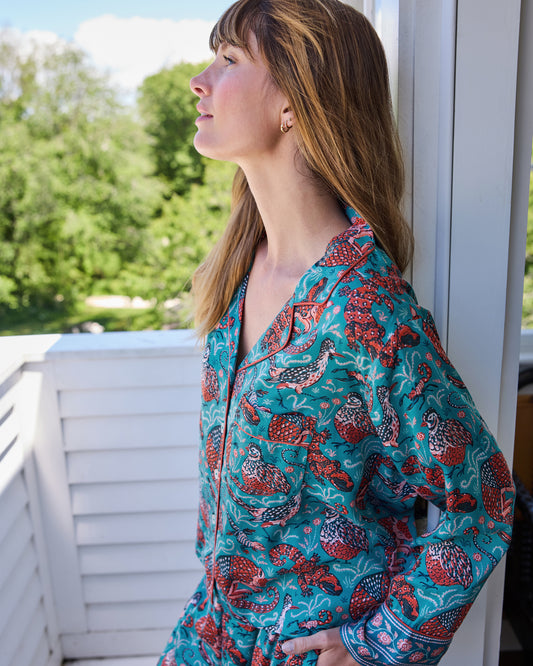 Side view of the teal Southwestern Critters satin Soho pajama top showing its collar, long sleeve, patterned cuff, and animal print.