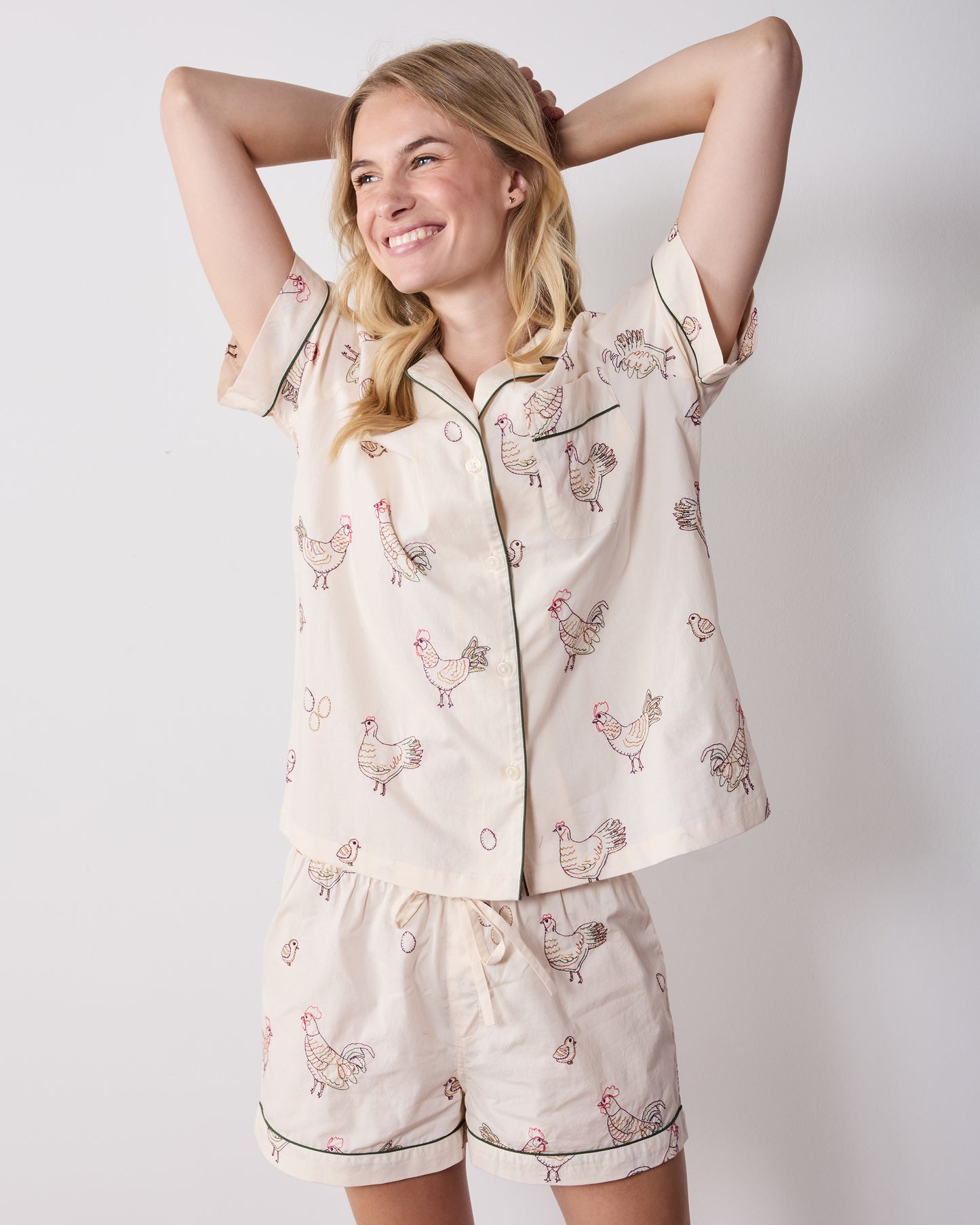 Front view of the short pajama set with a short-sleeve button-front top and matching shorts featuring embroidered hens.