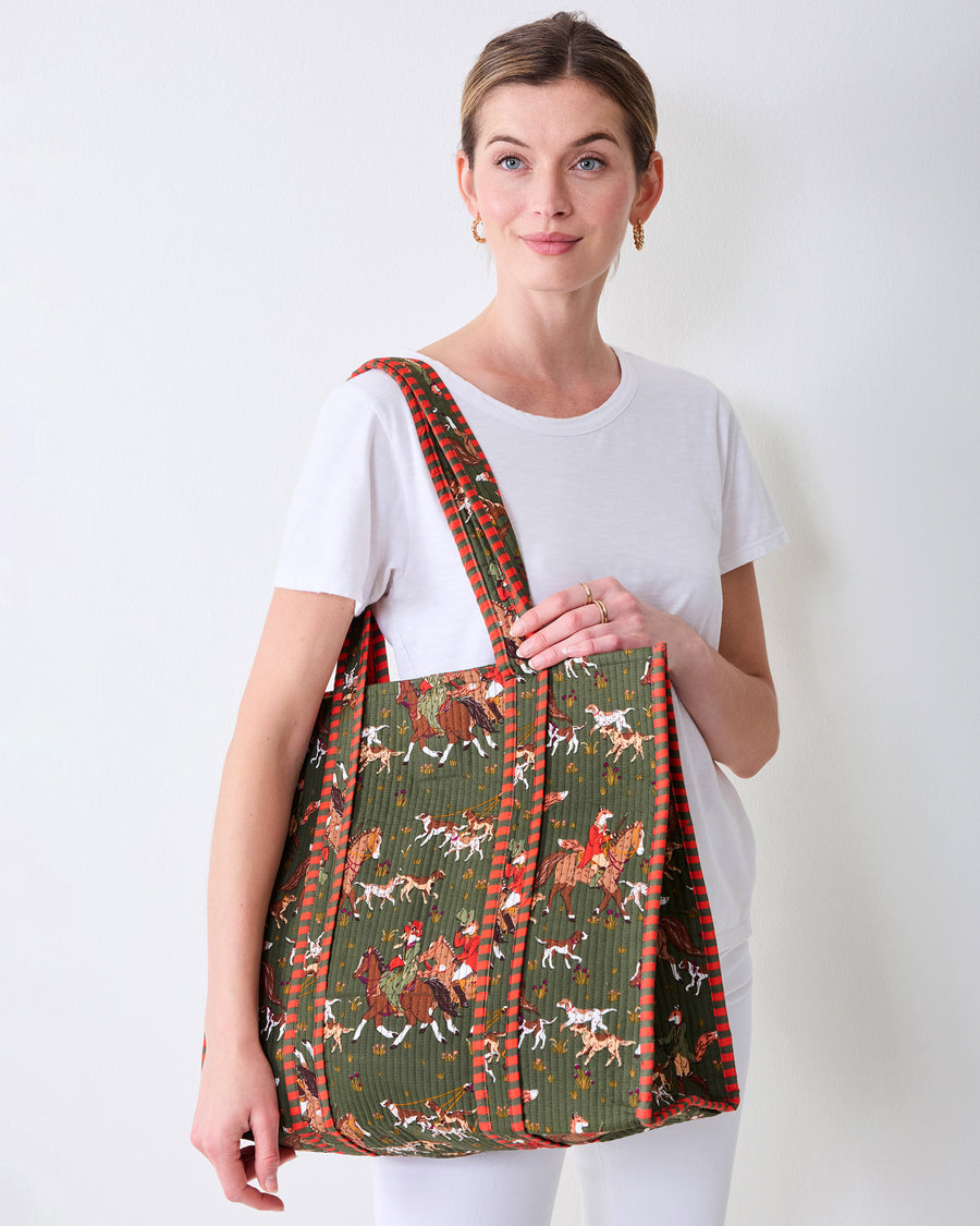 Front view of the Pine Grove Traveler Tote carried over one shoulder, showing its fox-and-hounds equestrian print.