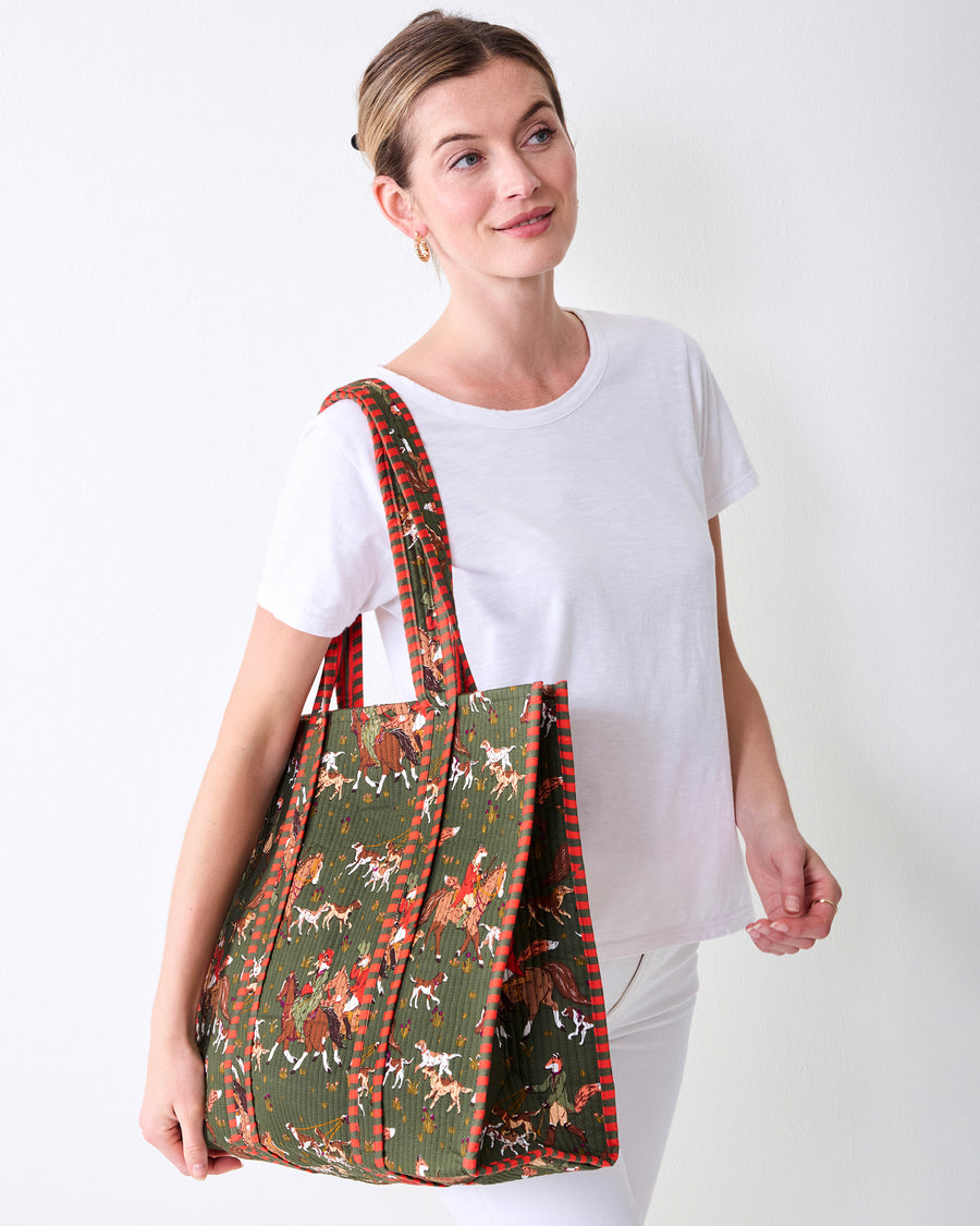 Angled front view of the Pine Grove Traveler Tote showing its fox-and-hounds print and striped trim.