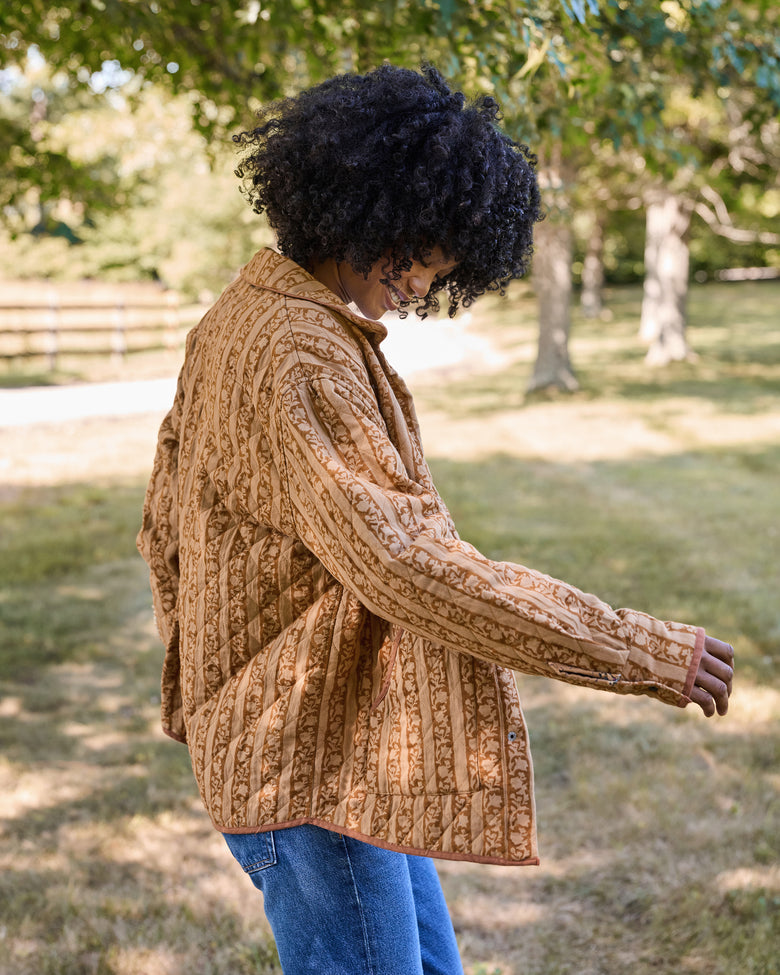 Back view of a patterned quilted jacket showing its vertical stripe design.