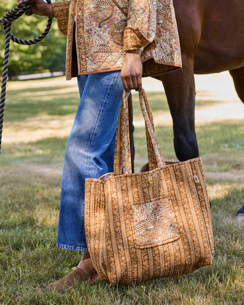 Reverse view of a quilted tote bag showing a front pocket with a spotted big-cat print and snap closure.