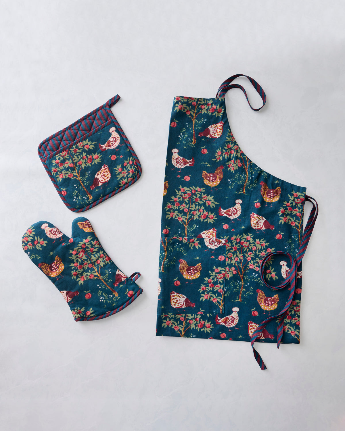 Navy chicken-print kitchen apron with matching pot holder and oven mitt.