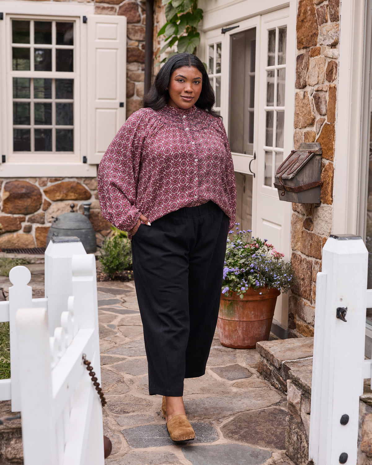 Full-length front view of the patterned Aspen blouse styled with black trousers.