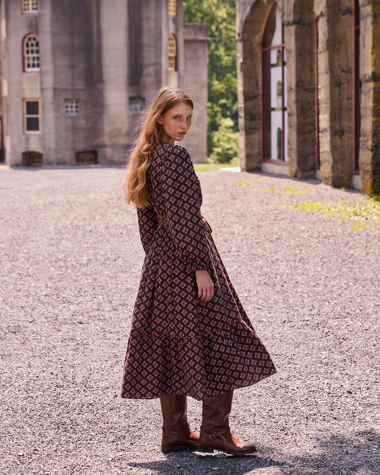 Back and side view of the patterned Shay midi dress with tall boots.