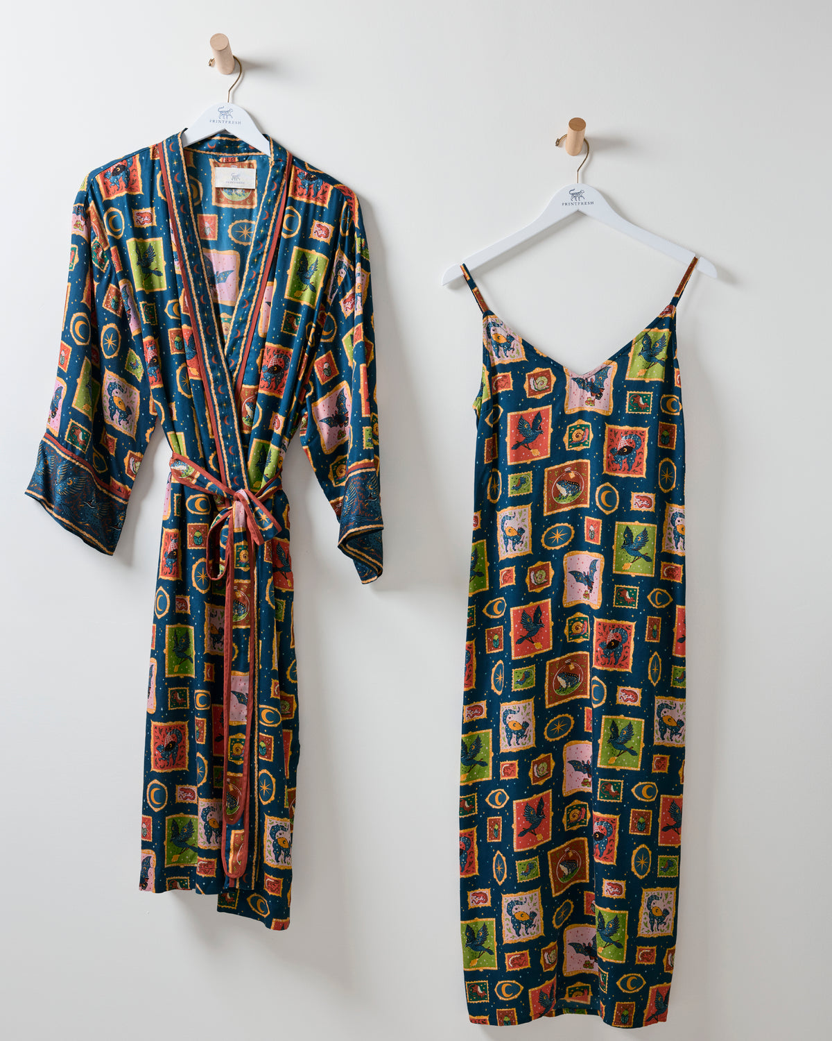 Dark blue patterned robe and matching sleeveless nightie hanging side by side.