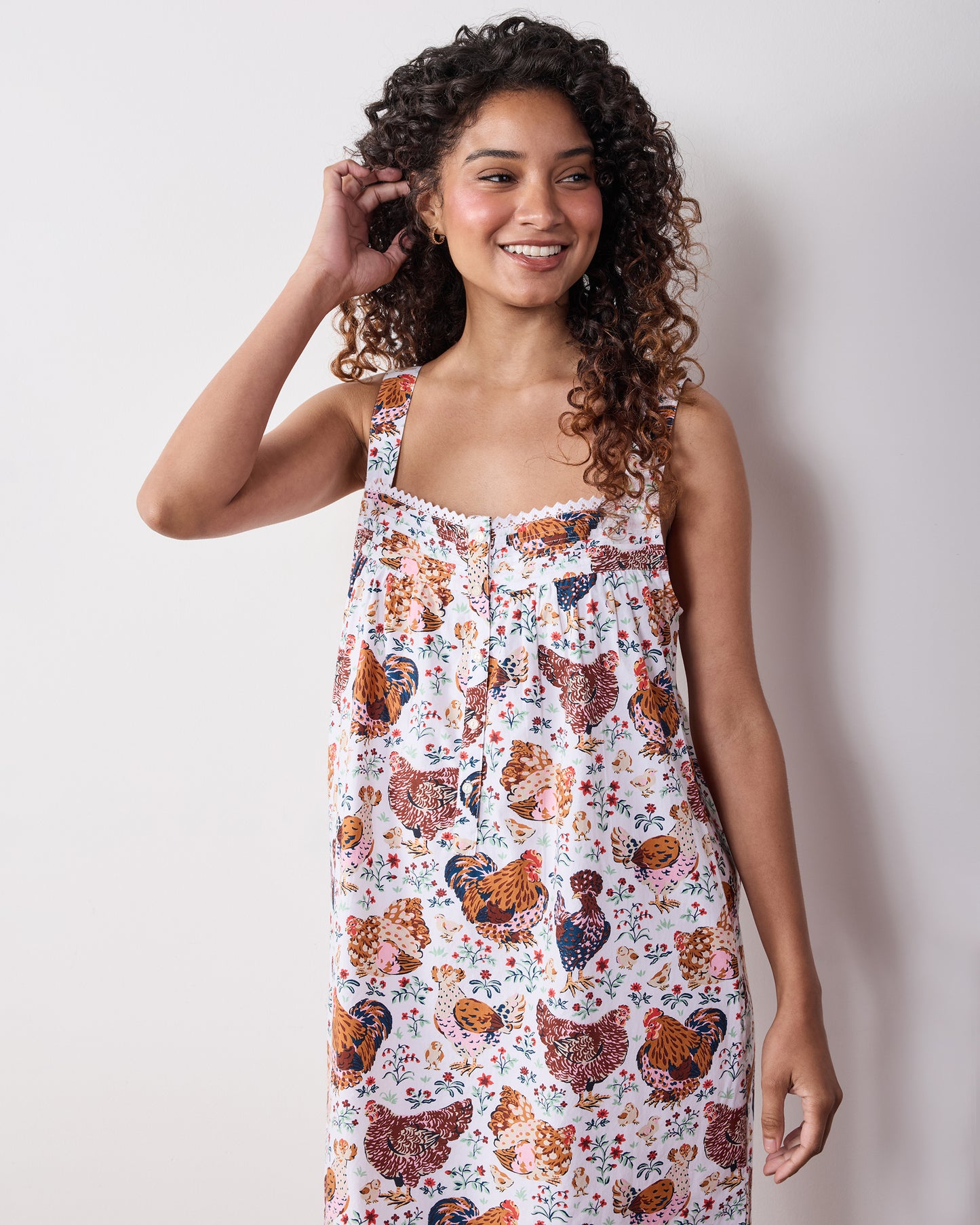Person wearing a floral chicken-print sleeveless nightgown against a light background.