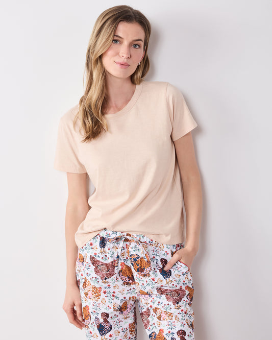 Front view of printed pajama pants with a drawstring waist and side pockets, worn with a plain short-sleeve shirt.