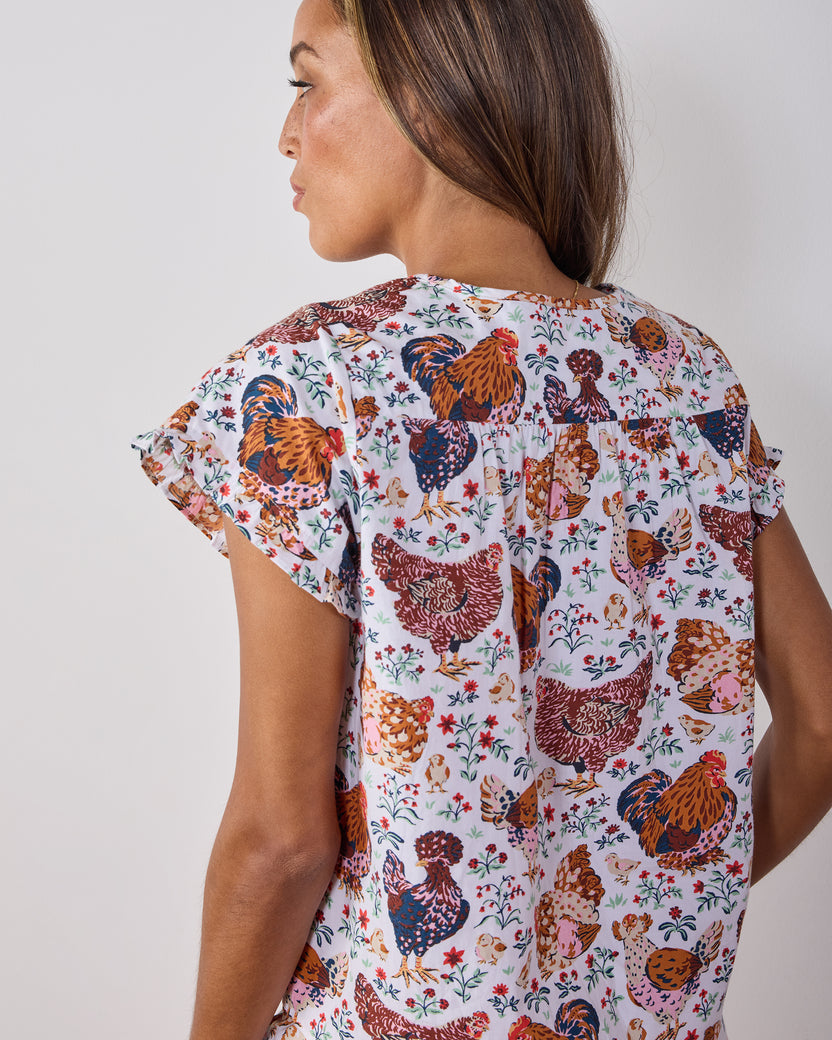Back view of a cropped short-sleeve top with a colorful chicken-and-floral print.