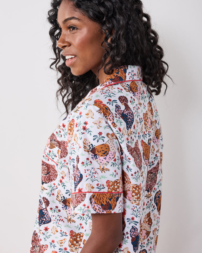 Close side-and-back view of a short-sleeve pajama top with a chicken-and-floral print.