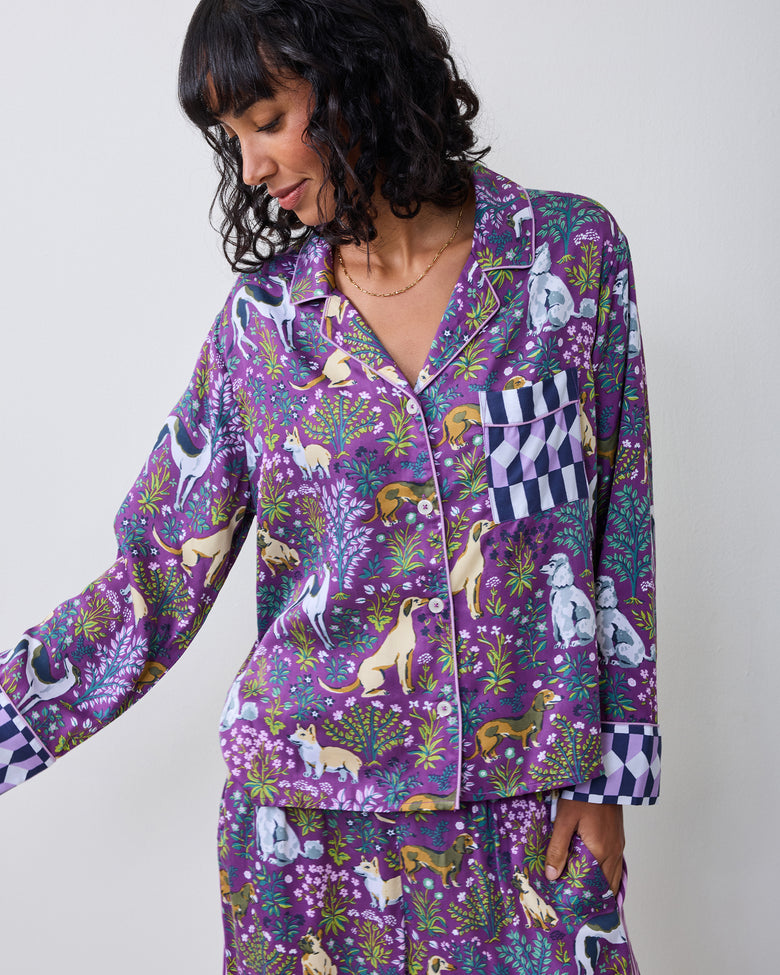 Model wearing a purple dog-print pajama shirt with a checkerboard pocket and cuffs.