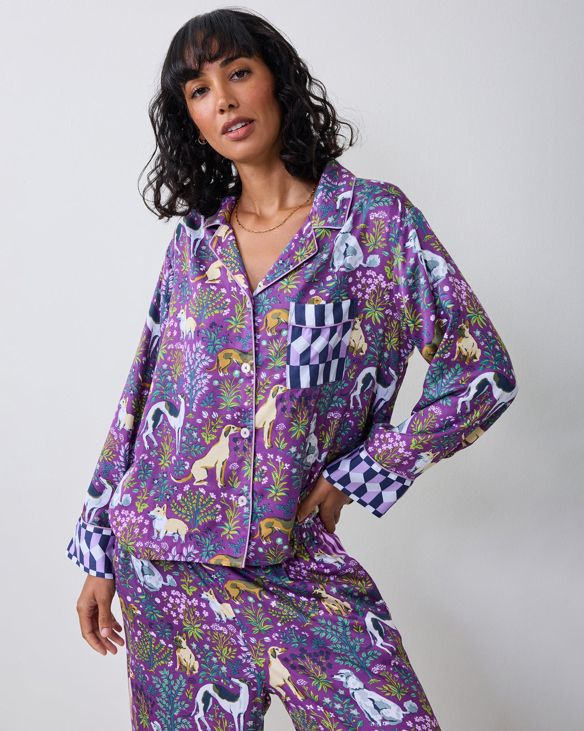 Model wearing a purple dog-print pajama set with a button-front shirt and wide-leg pants.