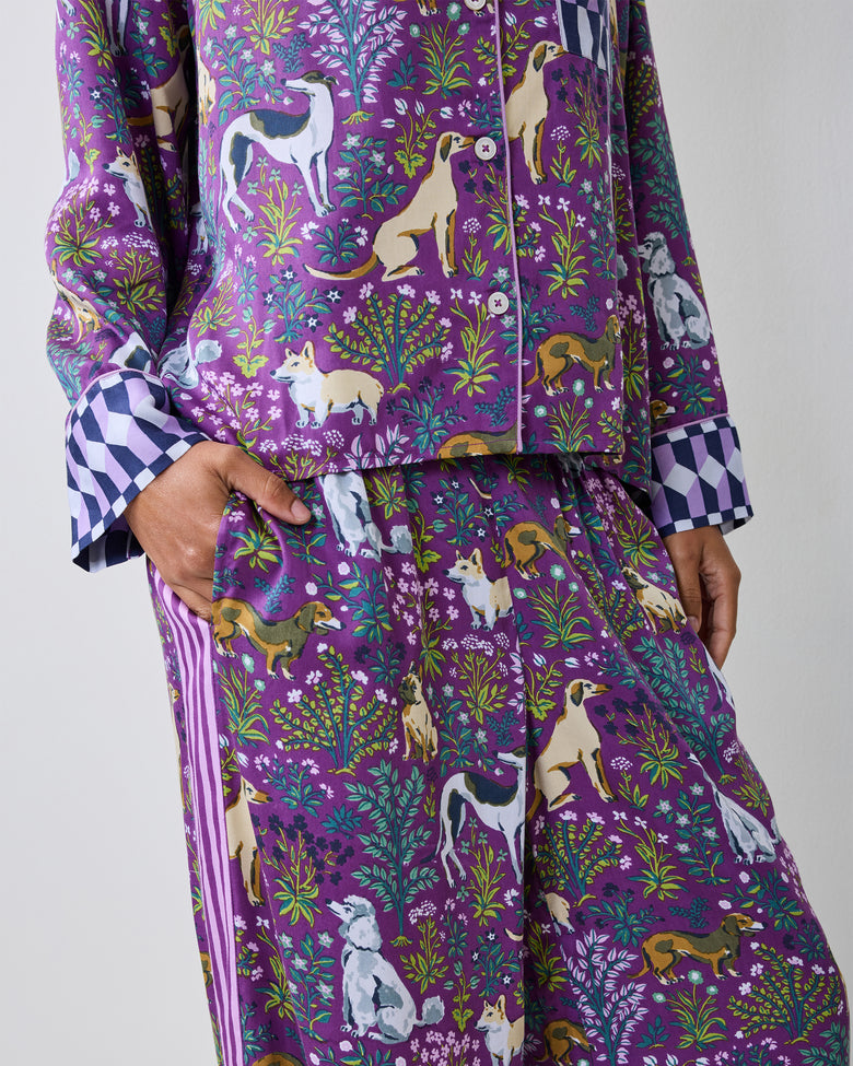 Close view of a purple dog-print pajama shirt and wide-leg pants with checkerboard cuffs.