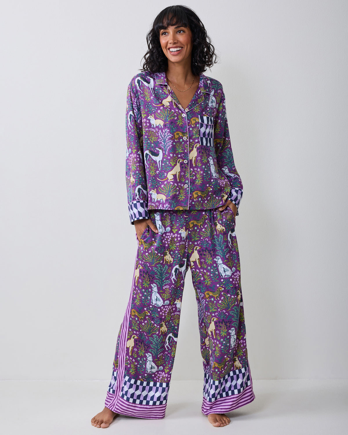 Full-length view of a model wearing a purple dog-print pajama set with wide-leg pants and contrasting lower cuffs.