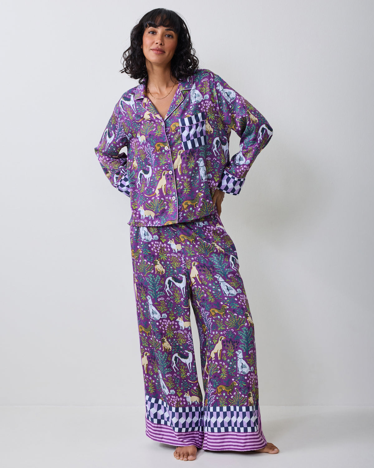Full-length front view of a model wearing a purple dog-print pajama set with wide-leg pants and contrasting cuffs.