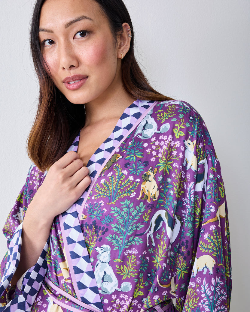 Close-up front view of a purple dog-and-floral print wrap robe with contrasting geometric trim and a matching belt.