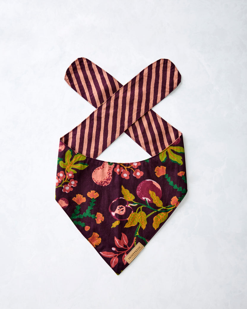 Front of a plum floral-print pet bandana laid flat, showing crossed striped ties
