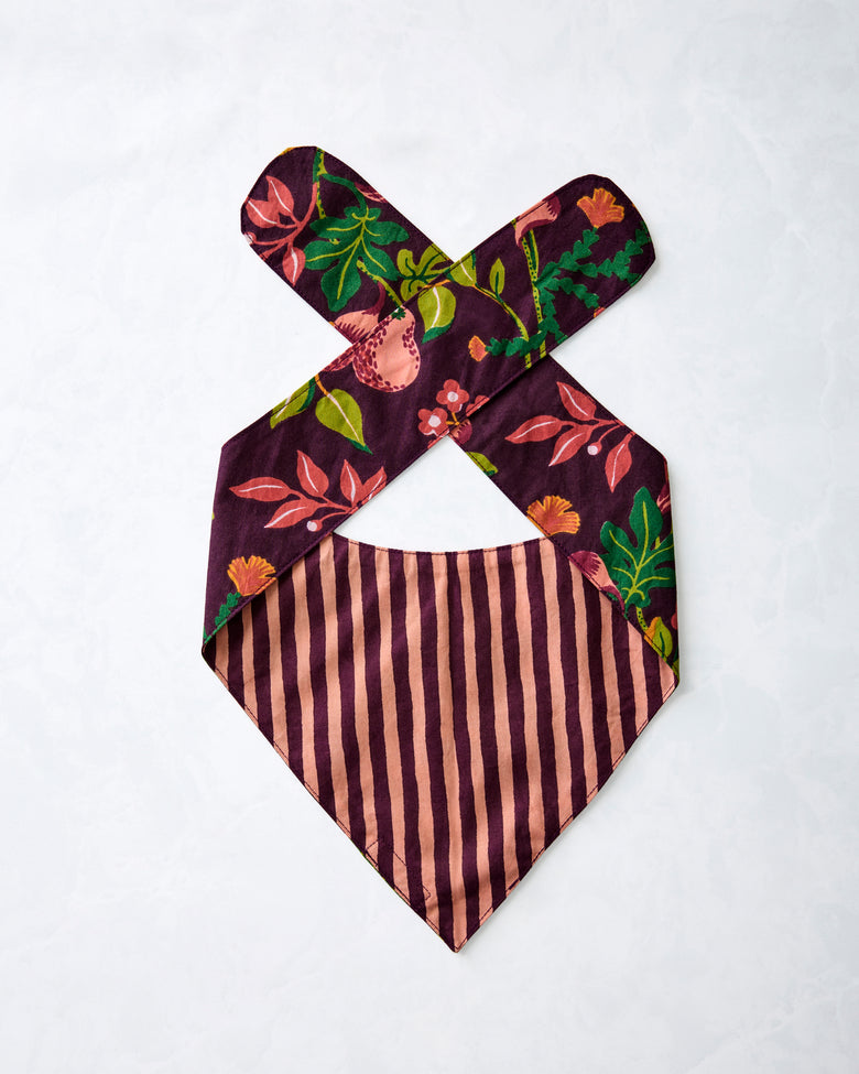 Reverse of a plum pet bandana laid flat, showing striped lining and floral-print ties