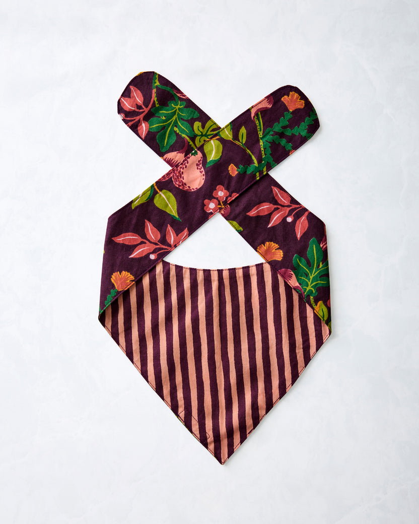 Reverse of a plum pet bandana laid flat, showing striped lining and floral-print ties